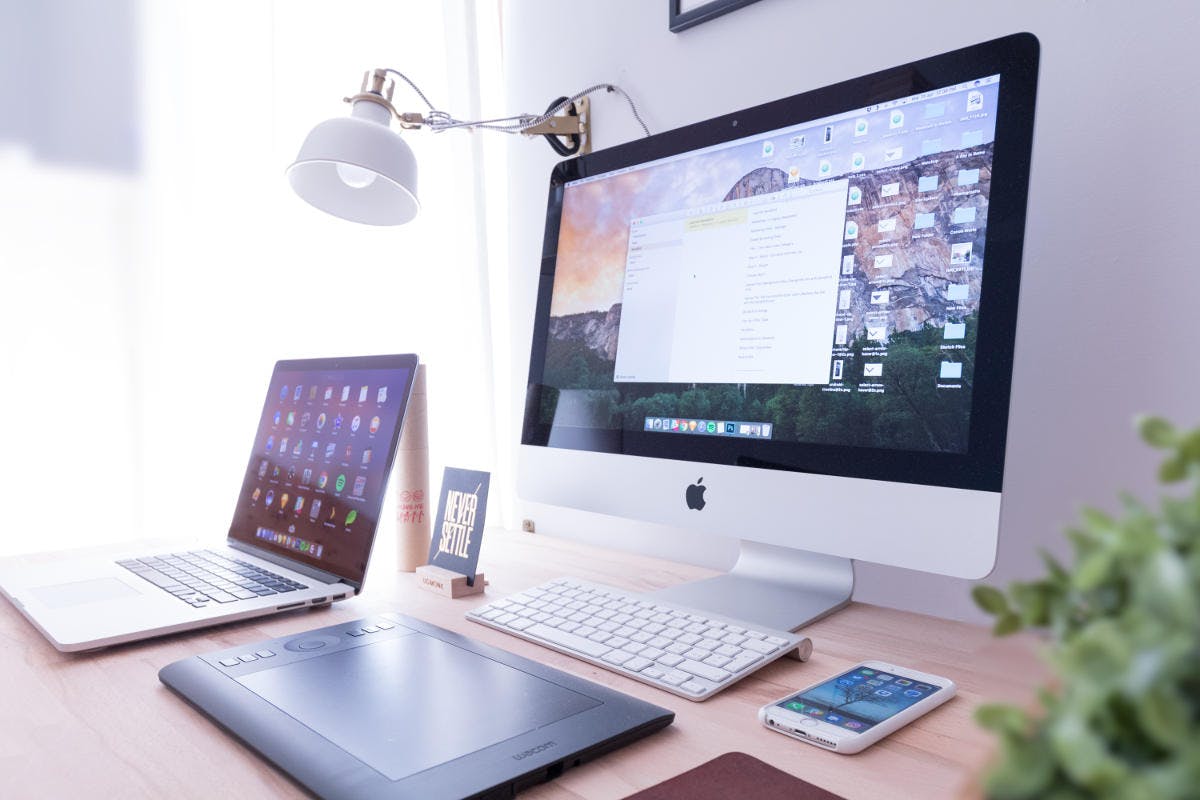Image of a IMac, laptop, tablet and smartphone on a desk