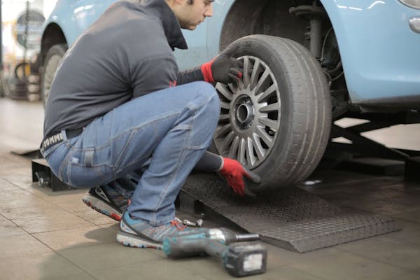 man-installing-rear-driver-side-tire