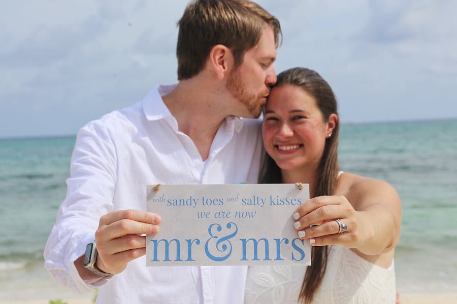 Close-up of rings and bouquet on white sand