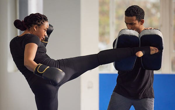 girl kickboxer kicking pads with her fitness kickboxing coach