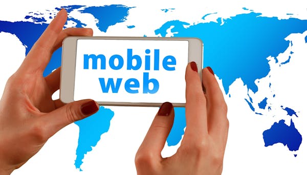 Image Of Hand Holding Mobile Phone With The Words 'Mobile Web@ And Background Of Continents