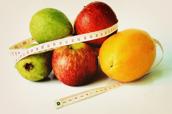 5 fruits with a measuring tape wrapped around the fruits