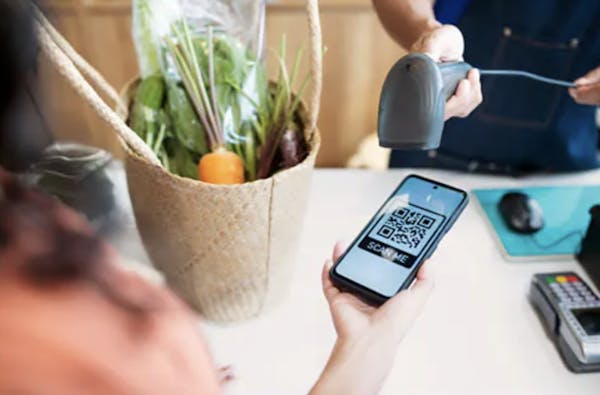 image of a woman scanning a QR code with her phone