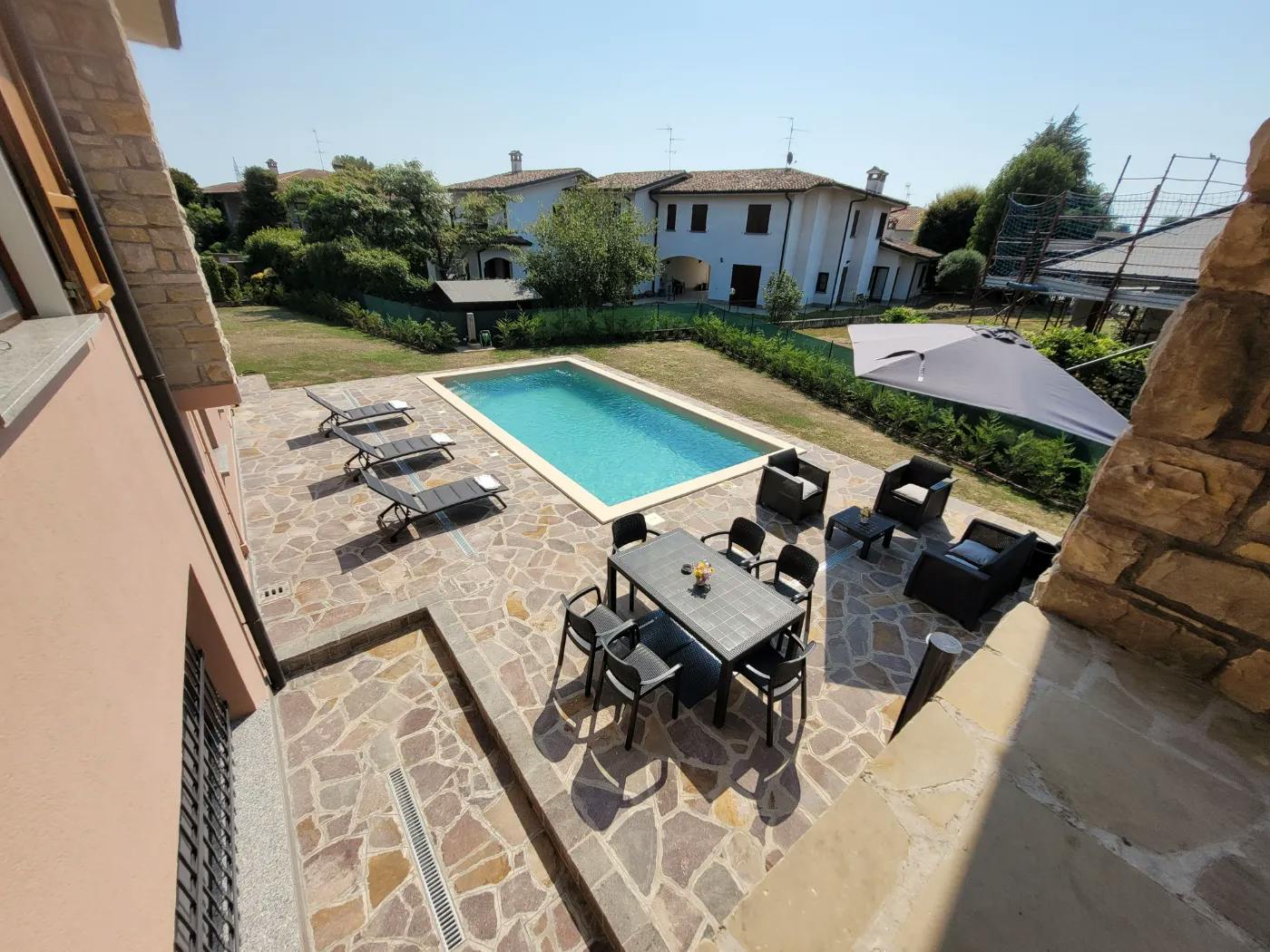 Piscina luxury villa con zona solarium e pavimentazioni design a Cremona